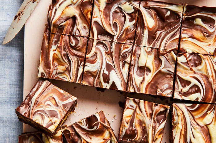 A tray of chocolate tiffin with swirled white chocolate and normal chocolate topping