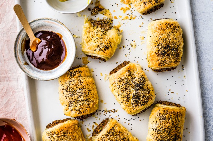 Vegan Sausage Rolls on a Baking Tray with BBQ Sauce for Dipping