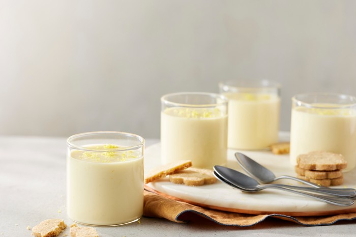 Four lemon possets in small glasses with shortbread on the side