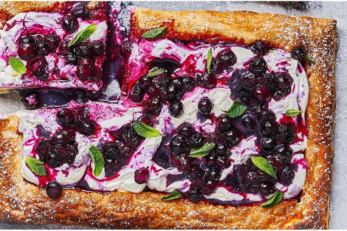 Rectangular pastry topped with mascarpone, blueberries and mint leaves