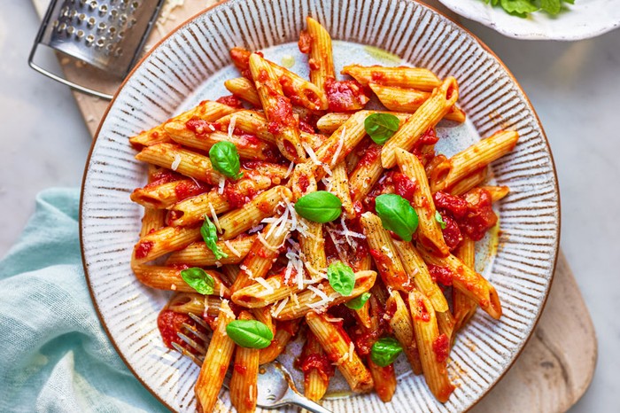 Penne pasta in tomato sauce topped with parmesan and basil